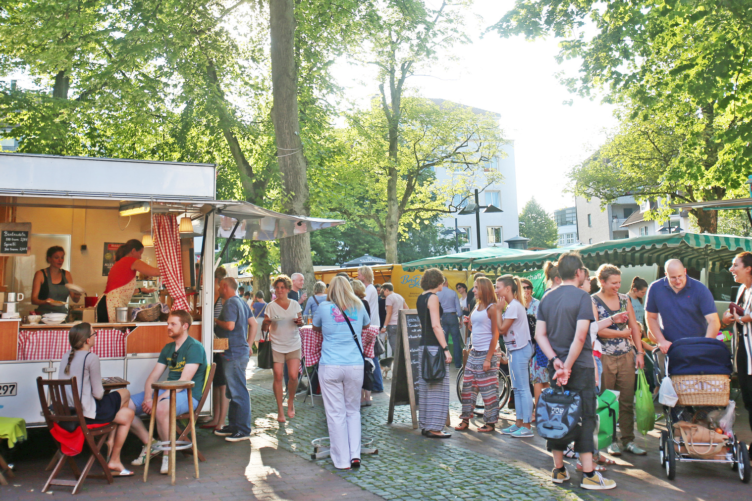 Menschen beim Wochenmarkt auf dem Siegfriedplatz.